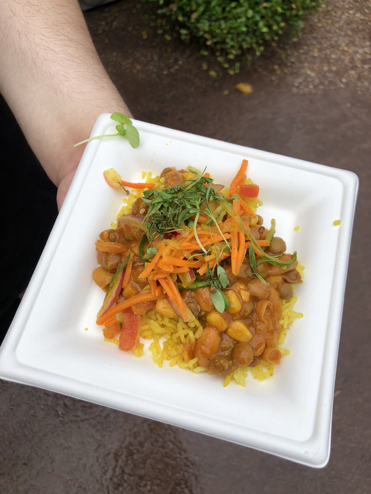 Brown beans with yellow rice and orange carrots on a white plate.