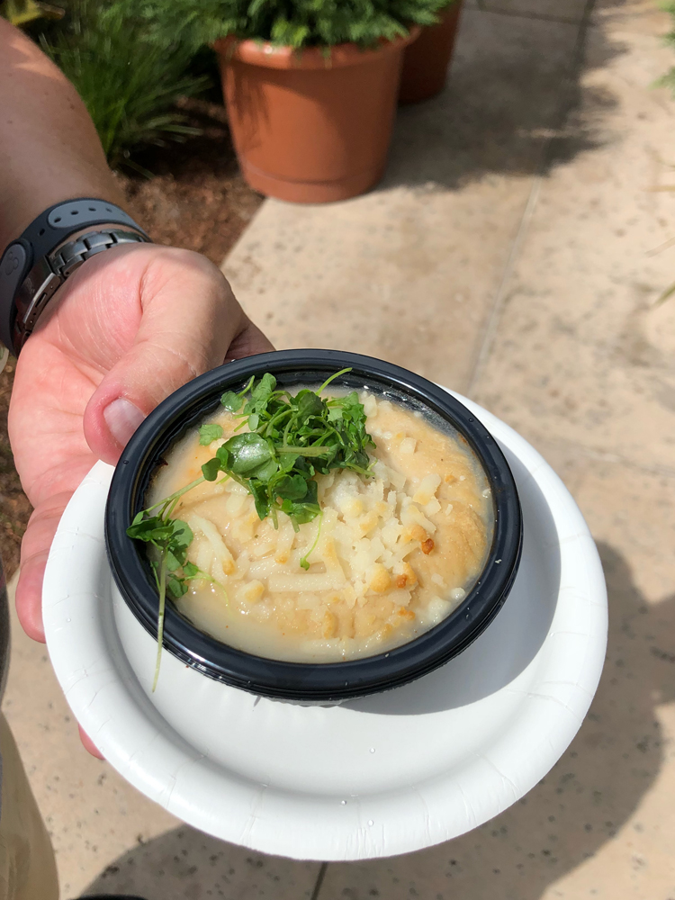 White cottage pie with green on top on a white plate