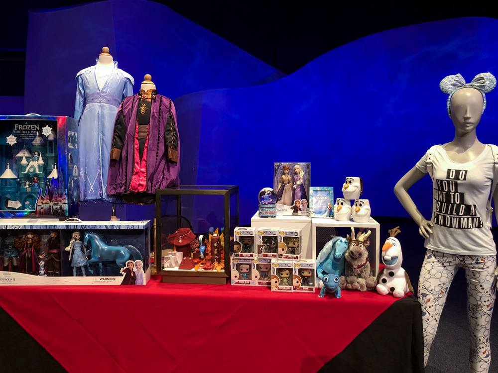 Various merchandise of toys and shirts for Frozen 2 on a table