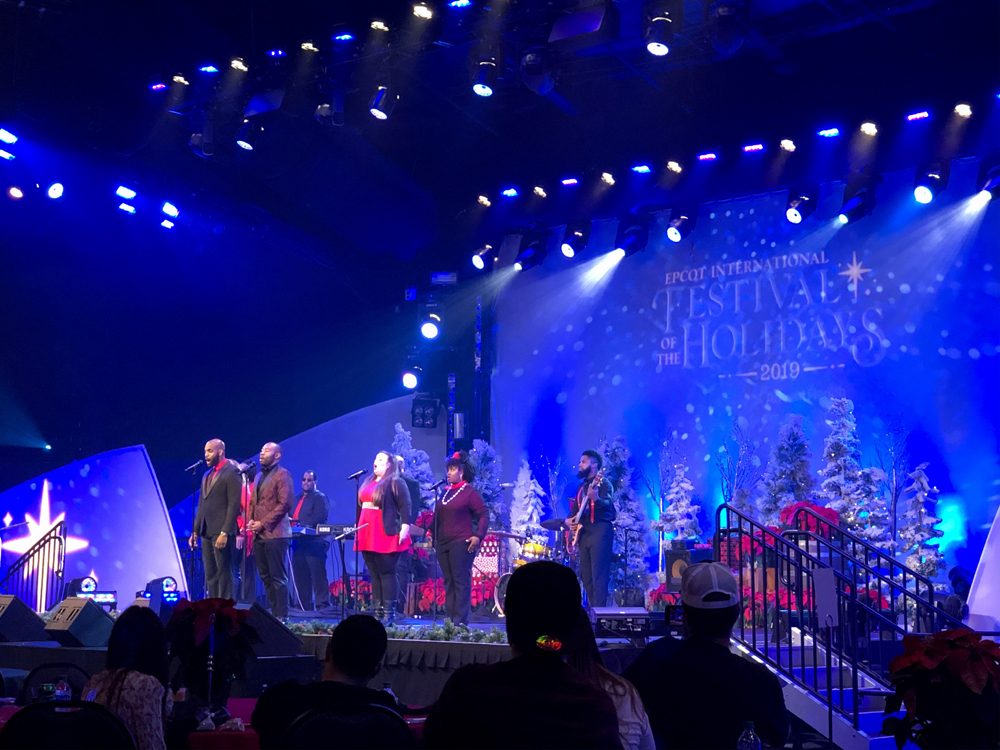 Blue lighting of a stage with men and women singing