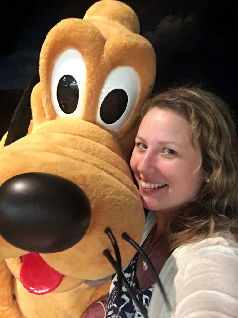 Yellow Disney World Pluto Dog with a blonde haired girl.