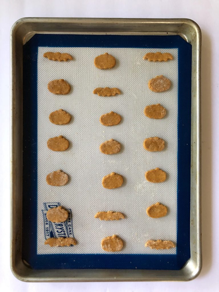 Peanut Butter Pumpkin Dog Treats on a white and blue silicone mat and stainless steel tray